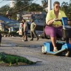 GTA 6: Los entusiastas rastrean a los animales en el tráiler, una obsesión fascinante. An iguana crossing a street near a woman on a scooter